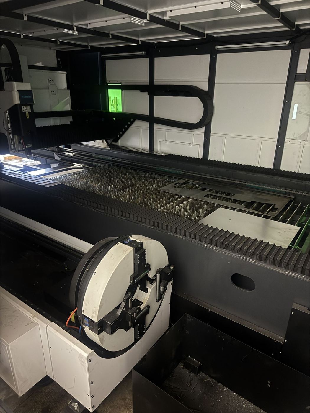 Inside the fiber laser showing the cutting bed and rotary tube chuck